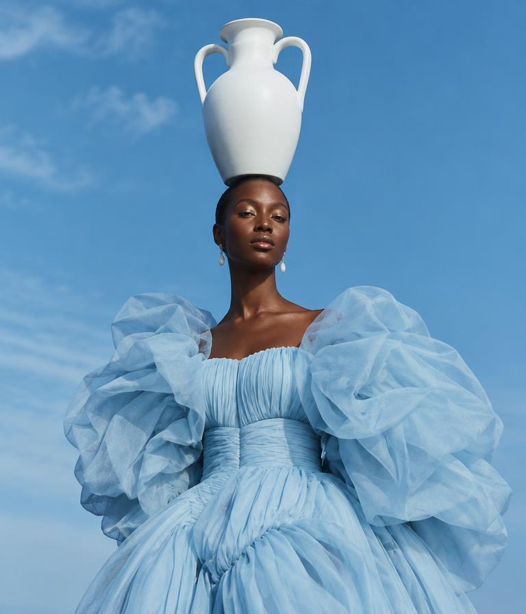 Figure in blue dress against sky